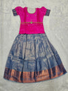 Hot pink semi silk top with steel blue bridal silk skirt pattu pavadai for girls featuring puff hand sleeves, waist belt detailing and double chain neck stone work by Sri Thulir Tex