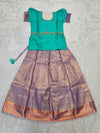 Teal green semi silk top with lavender bridal silk skirt pattu pavadai for girls featuring puff hand sleeves, waist belt design and double chain neck stone work by Sri Thulir Tex