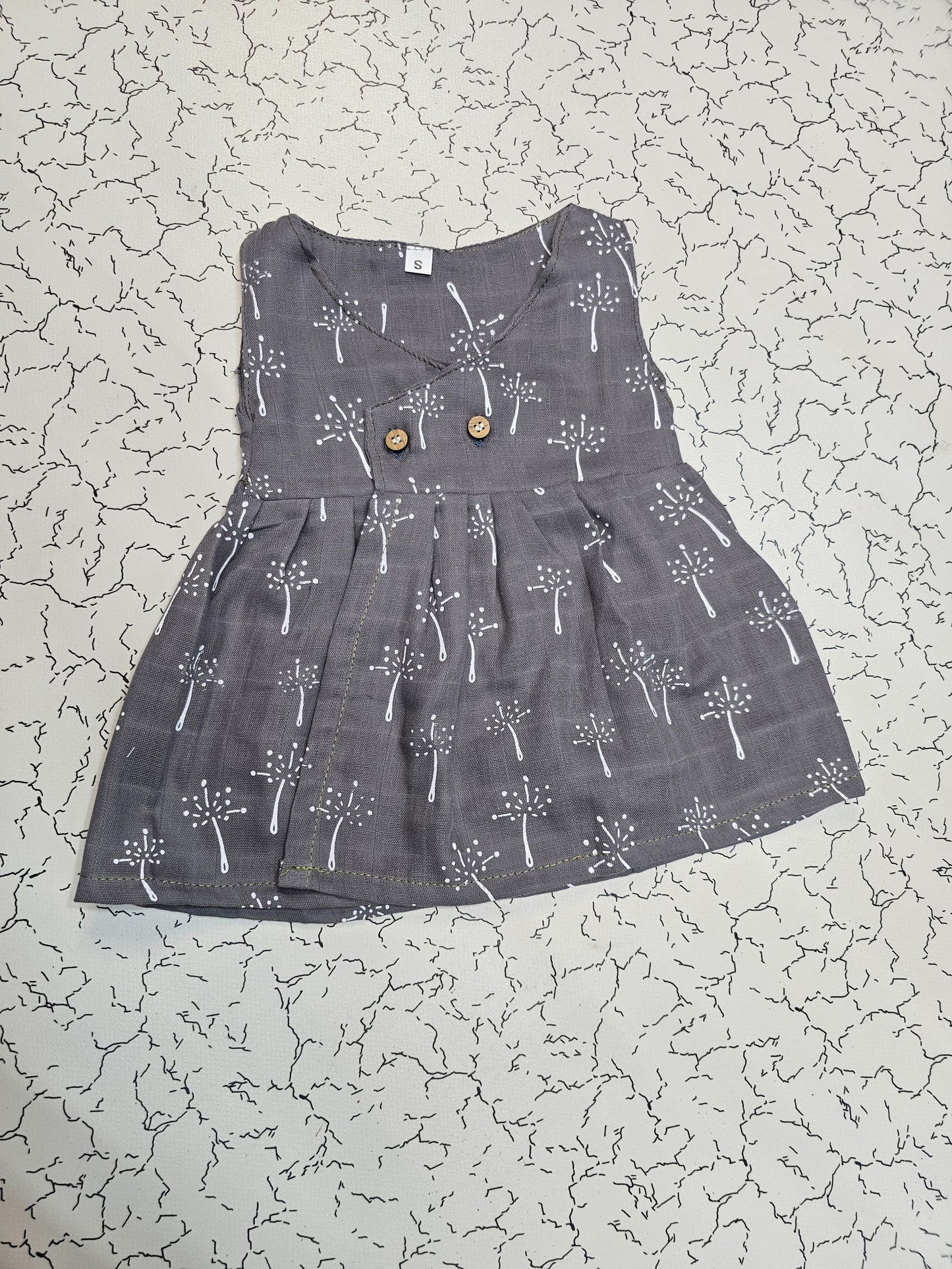 Dark grey muslin baby jabla frock with white multi print and wooden buttons for 0–6 months.