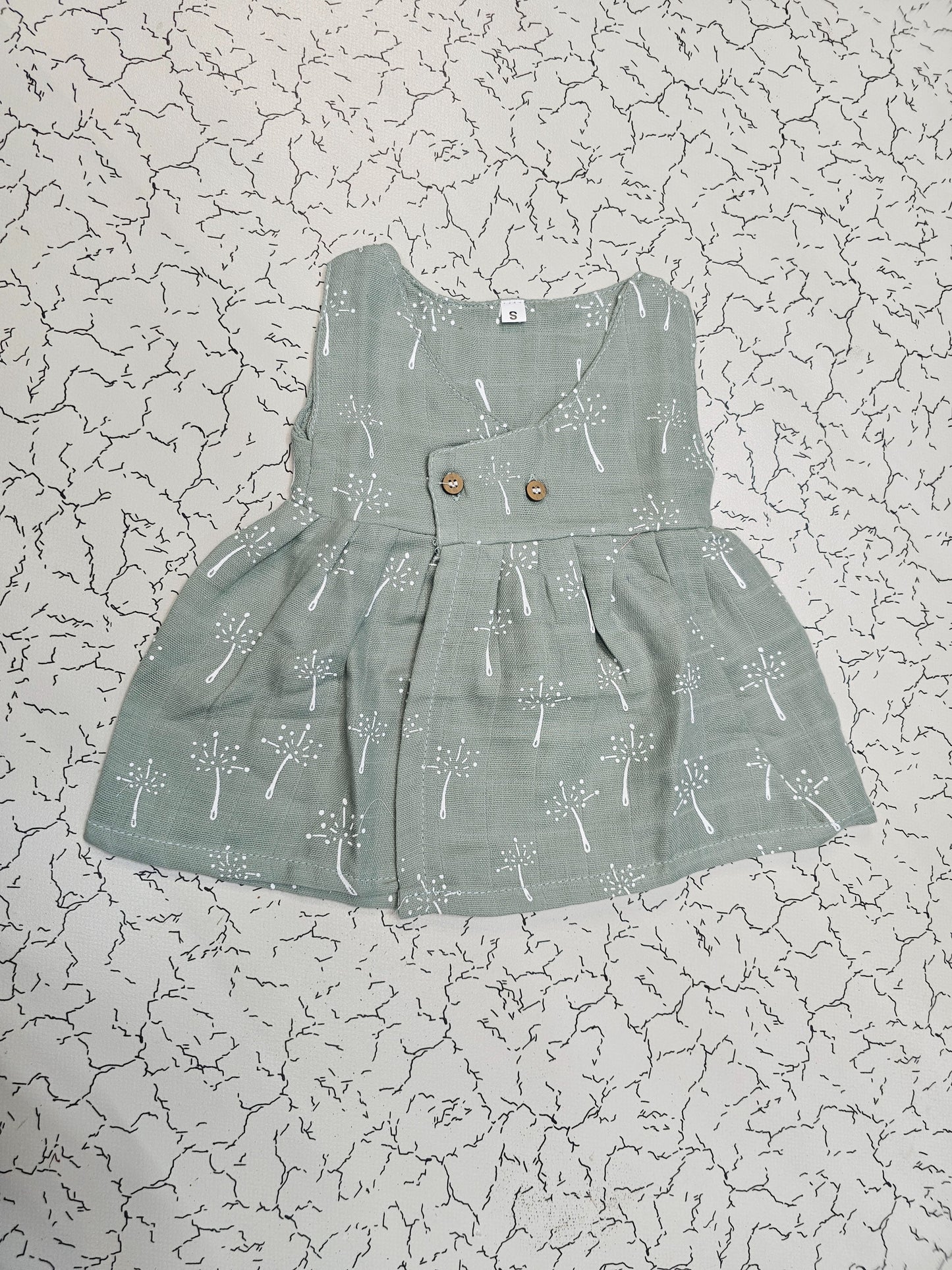 Grey green muslin baby jabla frock with white multi print and button design for 0–6 months.