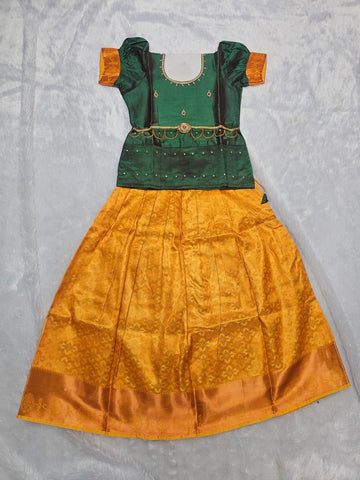 Bottle green semi silk top with mustard gold bridal silk skirt pattu pavadai for girls featuring puff hand sleeves, waist belt design and double chain neck stone work by Sri Thulir Tex