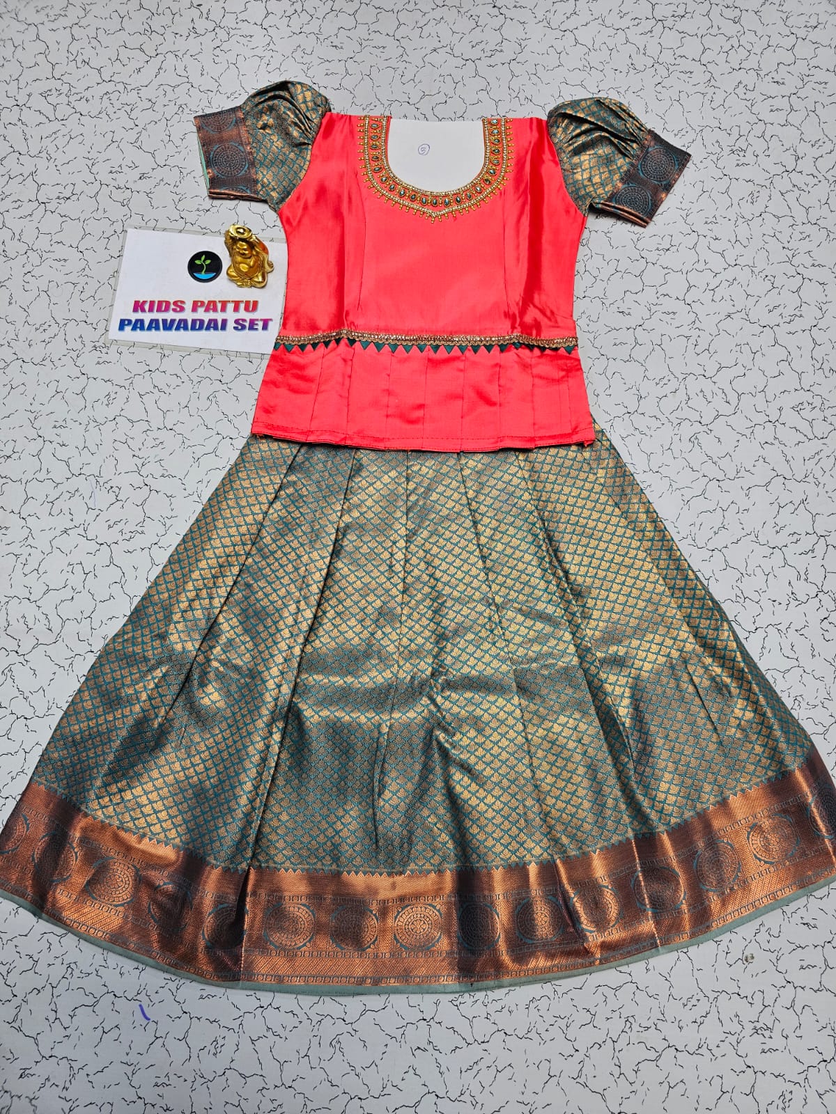 Coral pink and green kids pattu pavadai set with puff sleeves and zari bridal silk skirt by Sri Thulir Tex