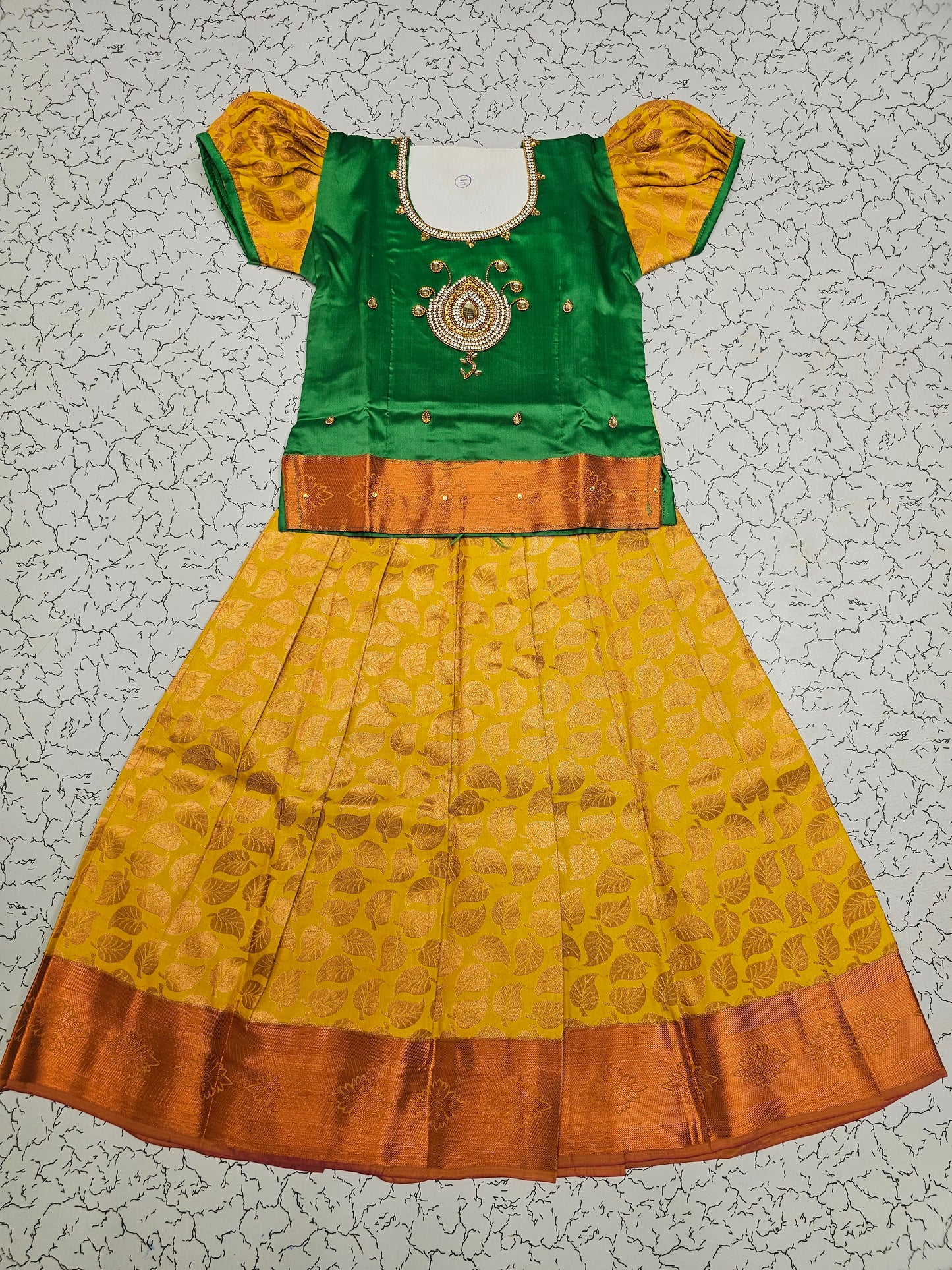 Green and mustard yellow silk pattu pavadai for girls with designer stone work blouse and zari leaf-patterned skirt – Sri Thulir Tex