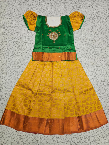 Green and mustard yellow silk pattu pavadai for girls with designer stone work blouse and zari leaf-patterned skirt – Sri Thulir Tex