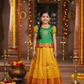Green and mustard yellow silk pattu pavadai for girls with designer stone work blouse and zari leaf-patterned skirt – Sri Thulir Tex