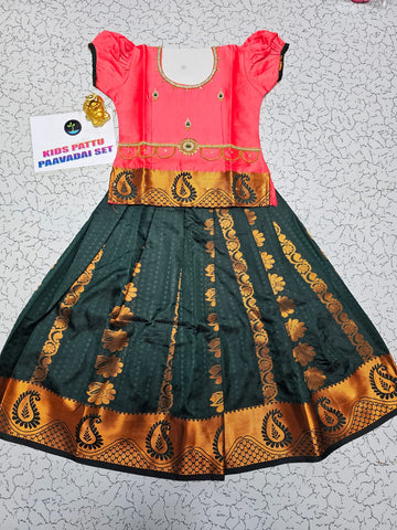 Kids Pattu Pavadai set with coral pink stone-work top and dark green zari woven skirt from Sri Thulir Tex.