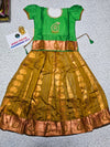 Kids Pattu Pavadai set with green stone-work top and mustard zari woven skirt from Sri Thulir Tex.
