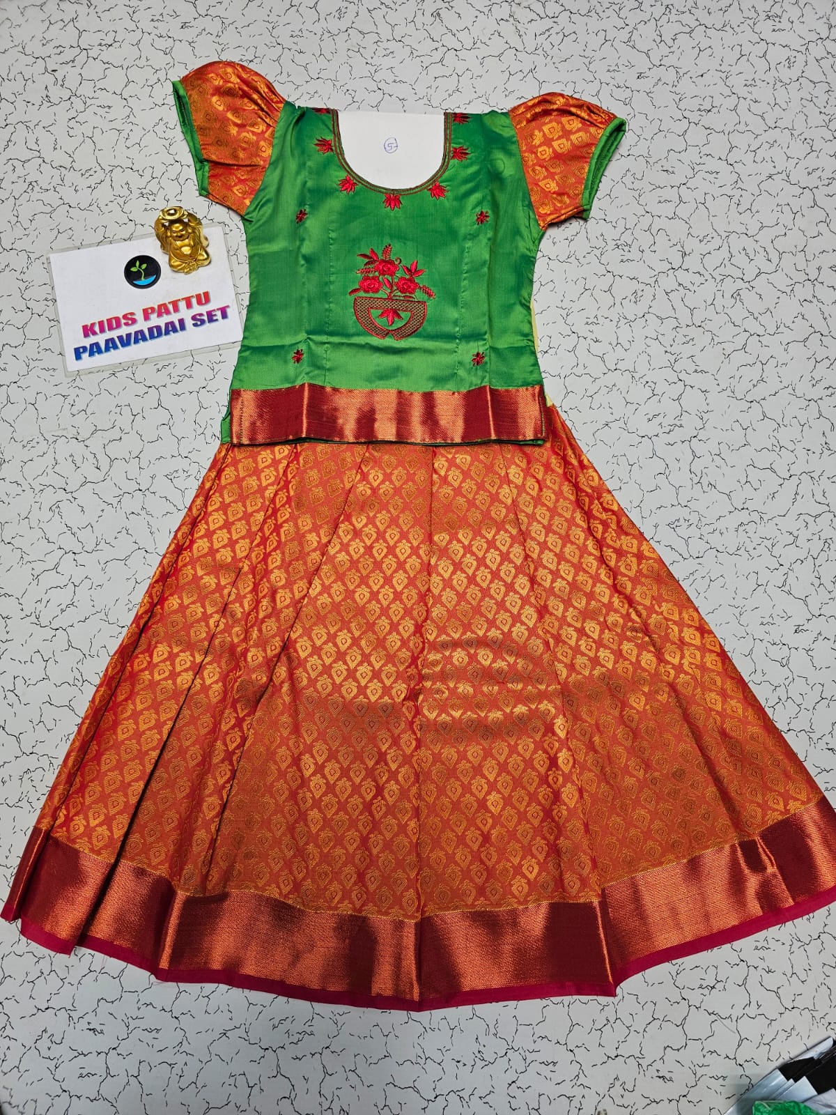 Kids pattu pavadai set with green semi silk top and orange bridal silk skirt by Sri Thulir Tex