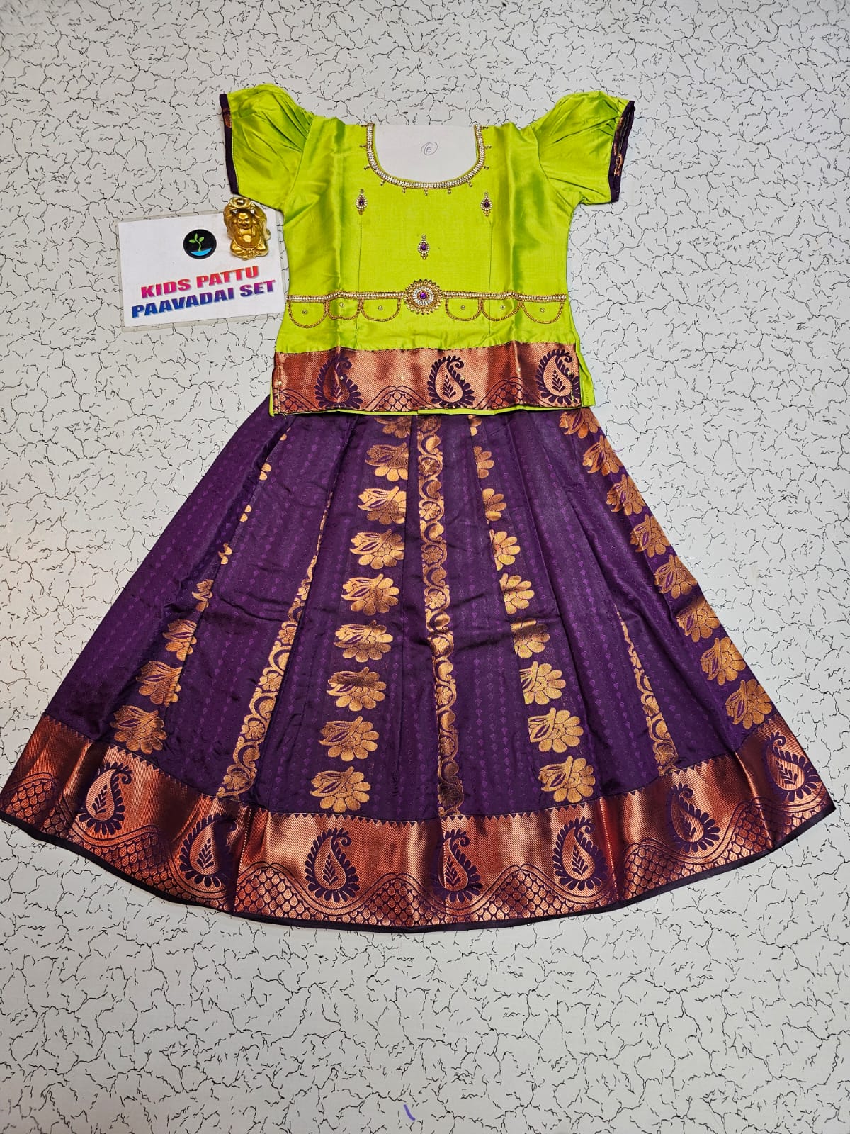 Kids Pattu Pavadai set with green semi-silk top and purple zari embroidered skirt from Sri Thulir Tex.