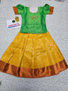 Kids pattu pavadai set with green semi silk top and yellow bridal silk skirt from Sri Thulir Tex