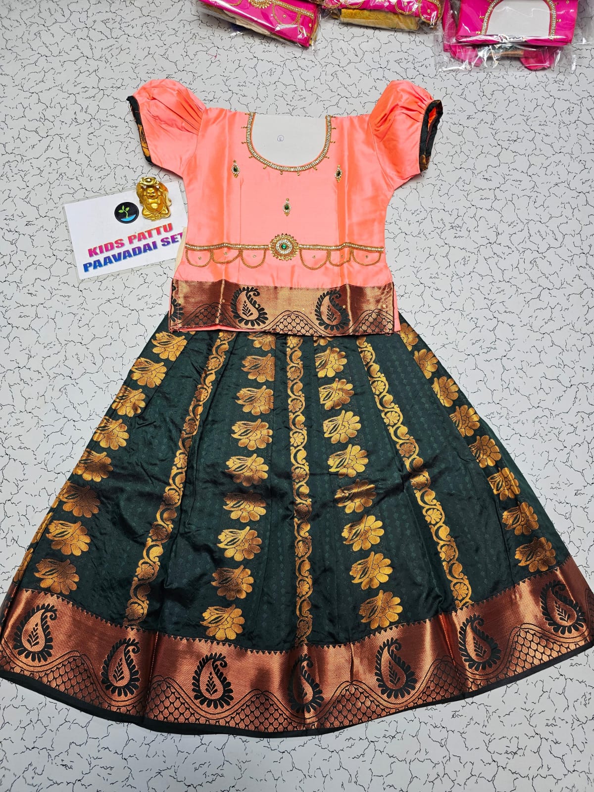 Kids Pattu Pavadai set with peach top and dark green zari woven skirt from Sri Thulir Tex.