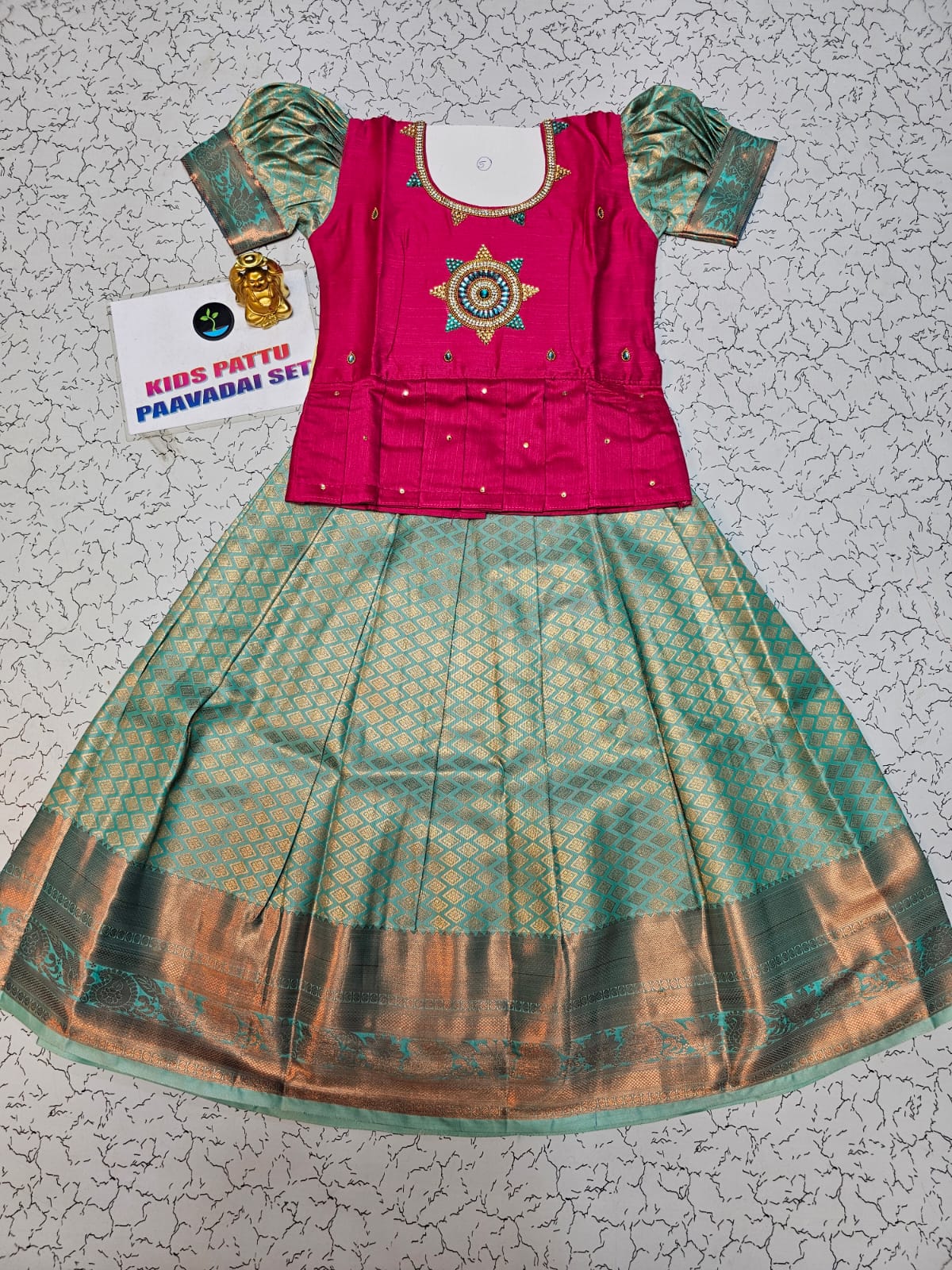 Kids pattu pavadai set with pink stone work blouse and green silk skirt by Sri Thulir Tex