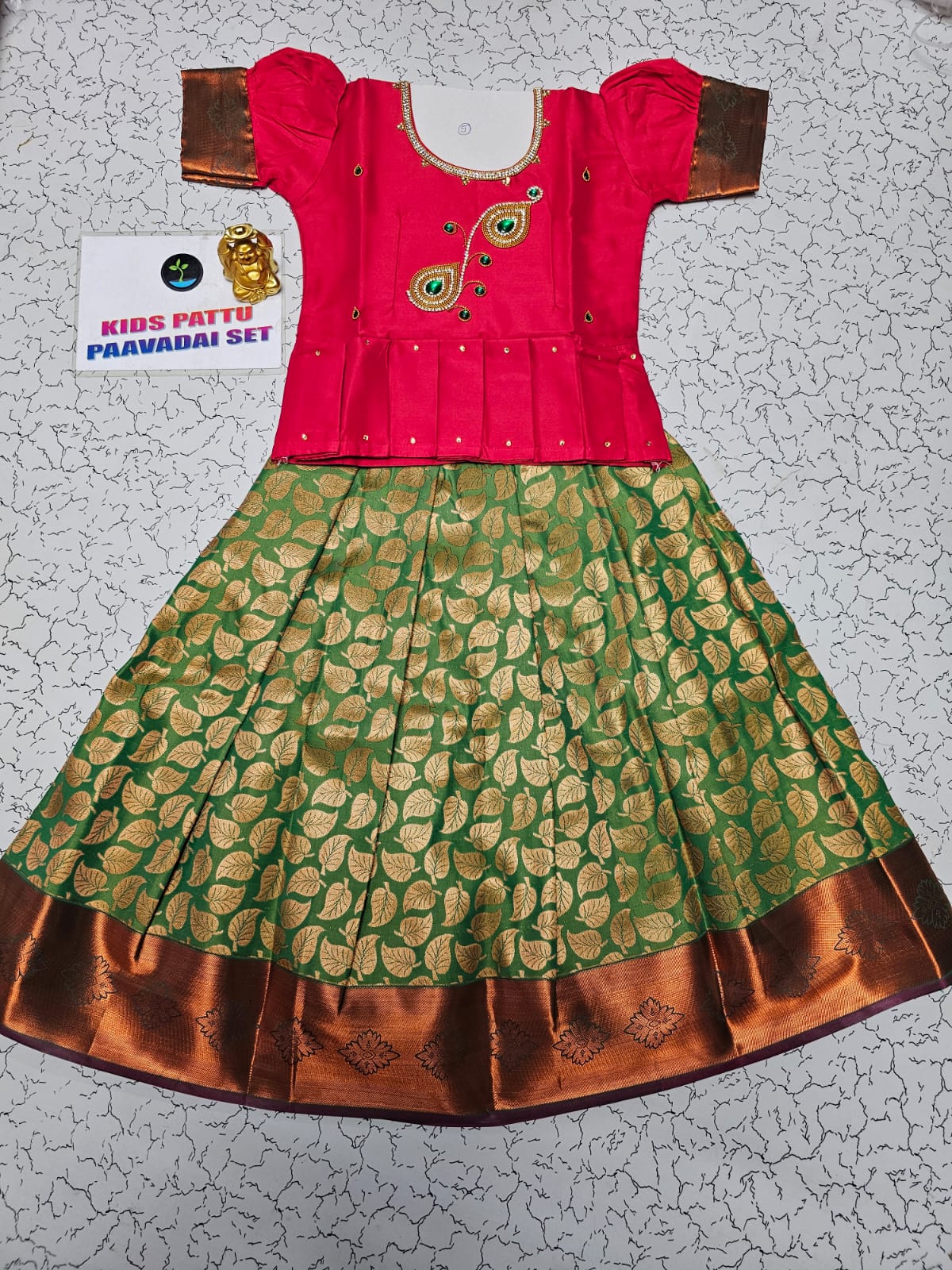 Kids pink semi-silk top with green and gold bridal silk pattu pavadai set by Sri Thulir Tex