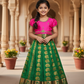 Kids Pattu Pavadai set with pink top and green zari woven skirt from Sri Thulir Tex.
