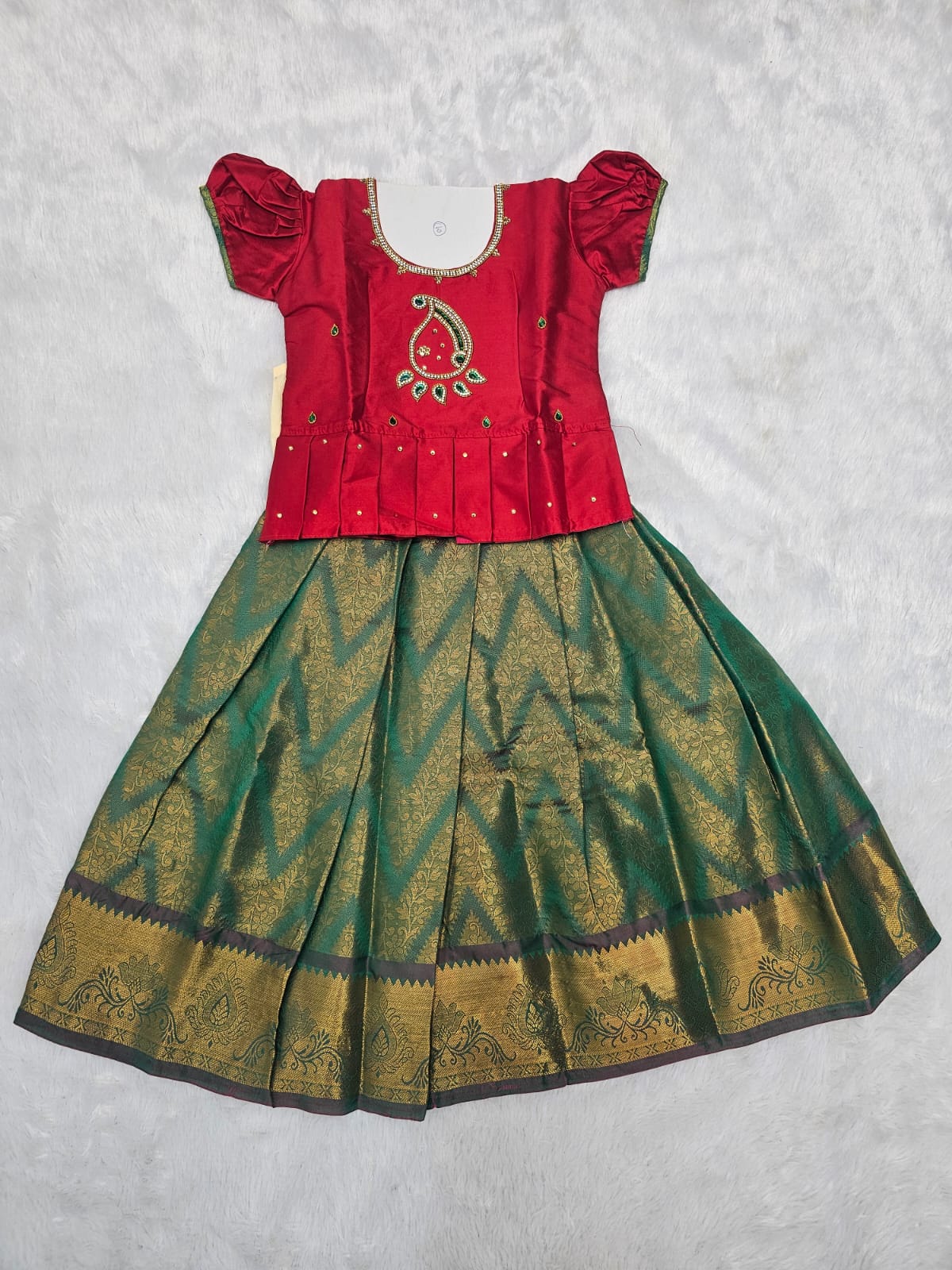 Kids red semi silk top with dark green bridal silk pattu pavadai set by Sri Thulir Tex