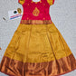 Kids pattu pavadai set with red semi-silk top and mustard gold bridal silk skirt from Sri Thulir Tex.