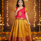Kids pattu pavadai set with red semi-silk top and mustard gold bridal silk skirt from Sri Thulir Tex.