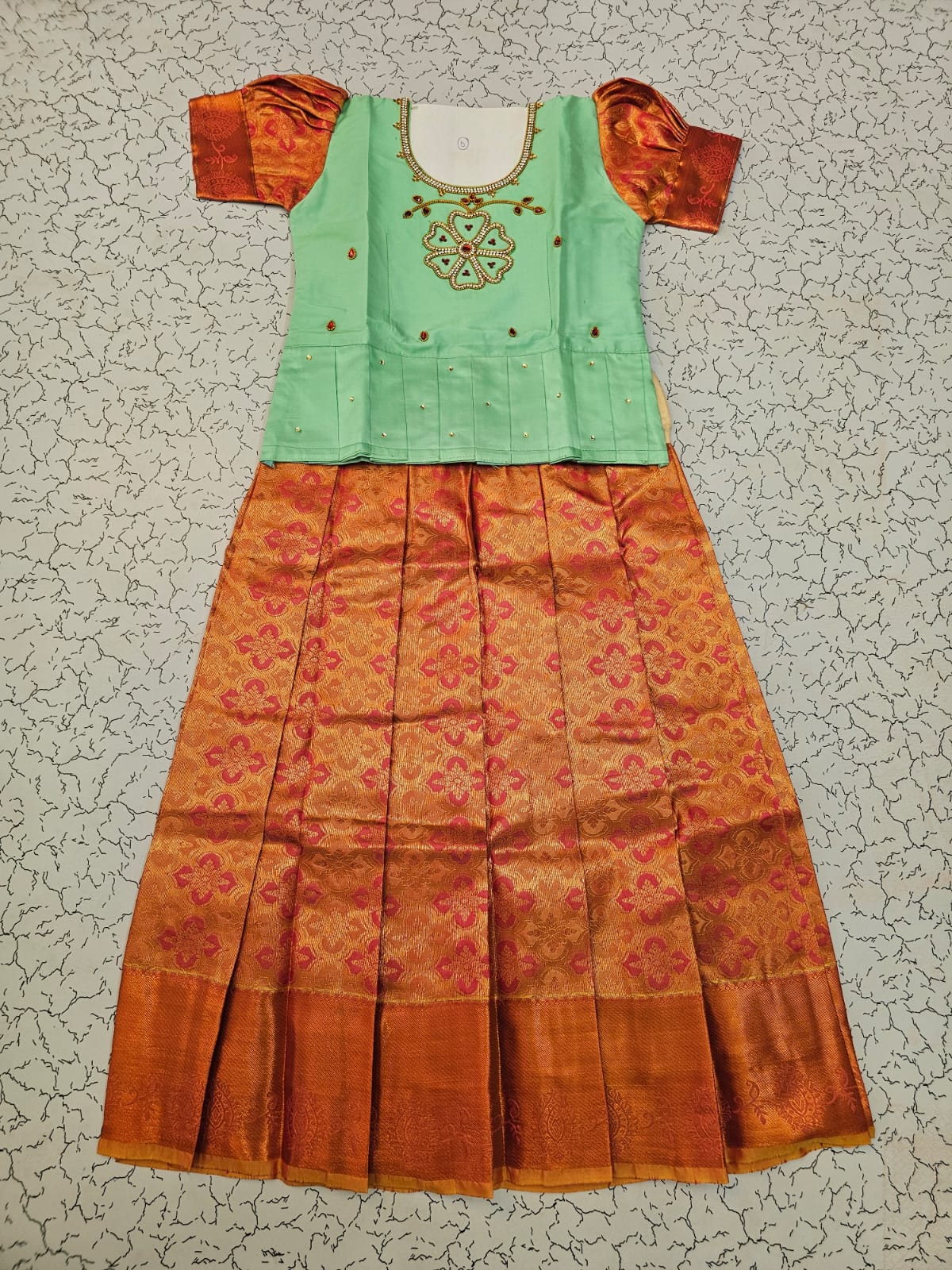 Kids pattu pavadai set with mint green semi silk top and orange bridal silk skirt by Sri Thulir Tex