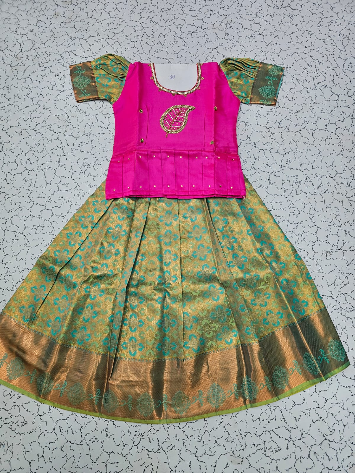Kids pattu pavadai set with pink semi silk top and green bridal silk skirt by Sri Thulir Tex