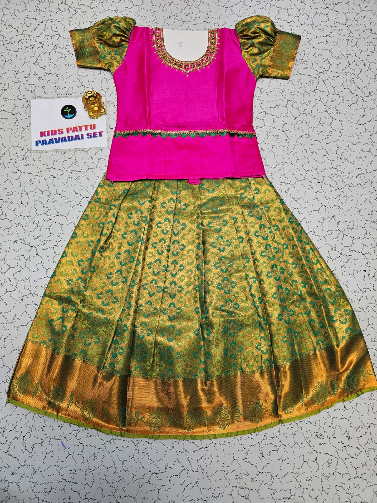Kids pink blouse and green silk pattu pavadai set with stonework and puff sleeves