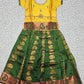 Kids Pattu Pavadai set with yellow stone-work top and green zari woven skirt from Sri Thulir Tex.