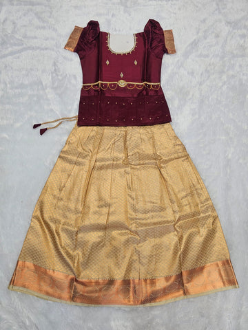 Maroon semi silk top with antique gold bridal silk skirt pattu pavadai for girls featuring puff hand sleeves, waist belt design and double chain stone neck work by Sri Thulir Tex