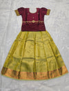 Maroon semi silk top with olive green bridal silk skirt pattu pavadai for girls featuring puff hand sleeves, waist belt detailing and double chain neck stone work by Sri Thulir Tex