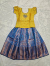 Golden yellow semi silk top with royal blue bridal silk skirt pattu pavadai for girls featuring puff sleeves and double chain stone neck work, traditional South Indian ethnic wear by Sri Thulir Tex