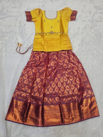 Mustard yellow semi silk top with wine maroon bridal silk skirt pattu pavadai for girls featuring puff hand sleeves, waist belt design and double chain neck stone work by Sri Thulir Tex