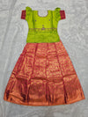 Parrot green semi silk top with rani pink bridal silk skirt pattu pavadai for girls featuring puff sleeves, waist belt detailing and double chain stone neck work by Sri Thulir Tex