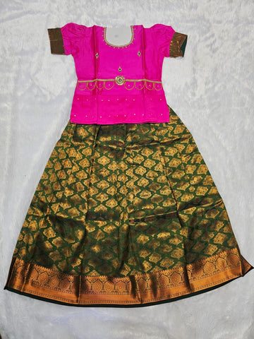 Pink semi silk top with green bridal silk skirt pattu pavadai for girls featuring puff hand sleeves, waist belt design and double chain neck stone work by Sri Thulir Tex