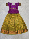 Purple semi silk top with green bridal silk skirt pattu pavadai for girls featuring puff hand sleeves, waist belt design and double chain neck stone work by Sri Thulir Tex