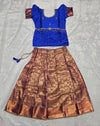 Royal blue semi silk top with antique gold bridal silk skirt pattu pavadai for girls featuring puff sleeves, waist belt design and double chain stone neck work by Sri Thulir Tex
