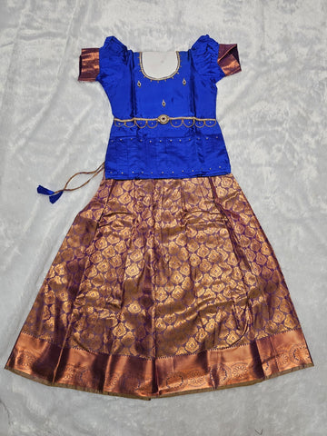 Royal blue semi silk top with antique gold bridal silk skirt pattu pavadai for girls featuring puff sleeves, waist belt design and double chain stone neck work by Sri Thulir Tex