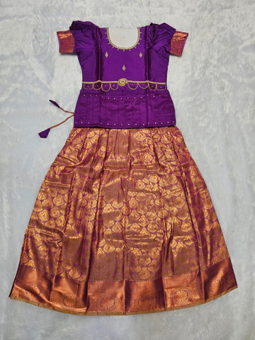 Royal purple semi silk top with antique gold bridal silk skirt pattu pavadai for girls featuring puff hand sleeves, waist belt detailing and double chain stone neck work by Sri Thulir Tex