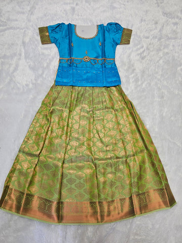 Sky blue semi silk top with green bridal silk skirt pattu pavadai for girls featuring puff hand sleeves, waist belt design and double chain neck stone work by Sri Thulir Tex