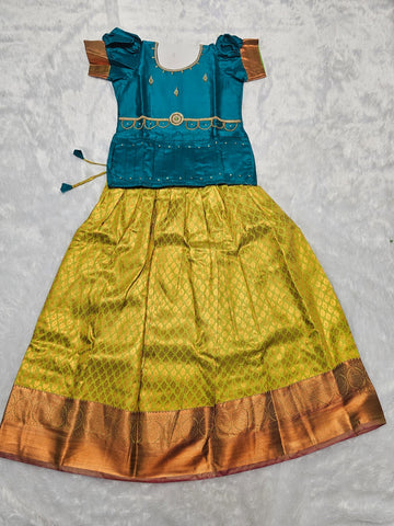 Teal blue semi silk blouse with lime green bridal silk skirt pattu pavadai for girls featuring puff sleeves, zari border and stone work detailing
