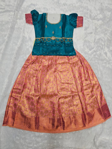 Teal blue semi silk top with rose pink bridal silk skirt pattu pavadai for girls featuring puff sleeves, waist belt detailing and double chain stone neck work by Sri Thulir Tex